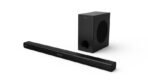 Black home theater speaker system with a long bar speaker and a separate rectangular subwoofer on a white background the bar has model text VCL 23 along its length