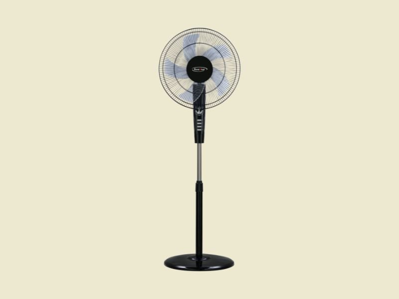 Black pedestal standing fan with a circular grille and translucent blades placed on a beige background