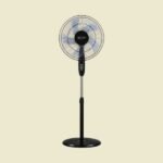 Black pedestal standing fan facing forward with visible blades and circular grill on a light beige background