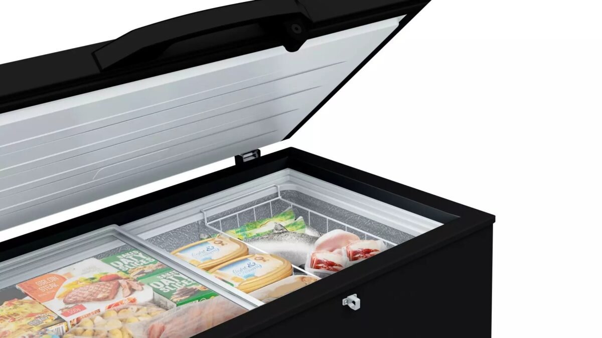 Open black chest freezer with its lid raised revealing frozen foods in packages inside