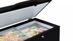 Open black chest freezer with its lid raised revealing frozen foods in packages inside