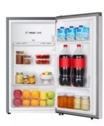 Open refrigerator showing groceries milk cartons on the top shelf juice cartons on the door jars of nuts and berries tomatoes citrus fruits and two bottles of cola on the door shelf