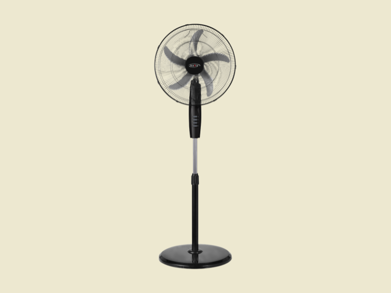 Black pedestal standing fan with a round grille on a beige background ready to cool a room