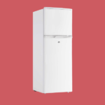 White vintage two door refrigerator with a top freezer on a solid red background