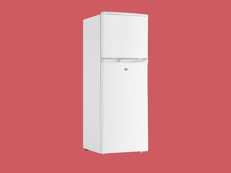 White vintage two door refrigerator with a top freezer on a solid red background