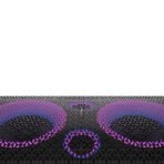Close up of a perforated black metal surface with a pinkpurple gradient light at the bottom of the frame