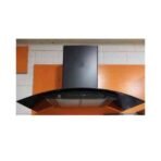 Curved black glass range hood mounted above a stove with orange wall panels in a modern kitchen