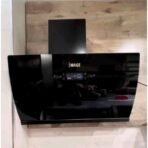 Glossy black wall mounted kitchen range hood with a digital control panel and curved front panel