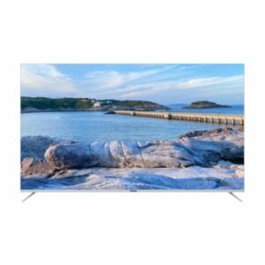 Flat screen TV showing a coastal seascape with rocks a breakwater and blue sky on the screen