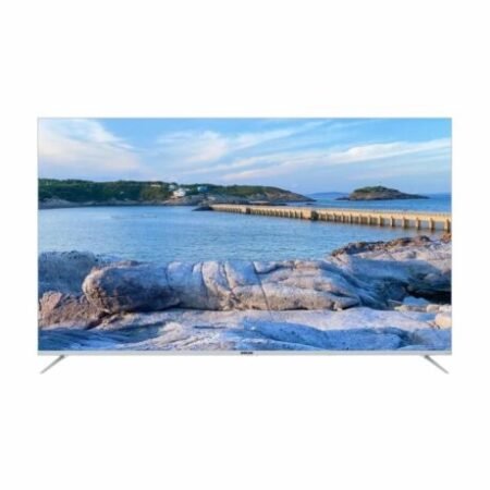 Flat screen TV showing a coastal seascape with rocks a breakwater and blue sky on the screen