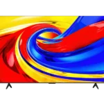 Flat screen TV on a black background displaying a vibrant abstract swirl in red blue and yellow with two stands at the bottom corners