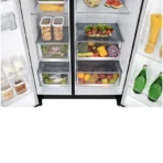 Open side by side refrigerator with organized vegetable drawers containing peppers greens berries and fruit door shelves hold bottles pasta and snacks